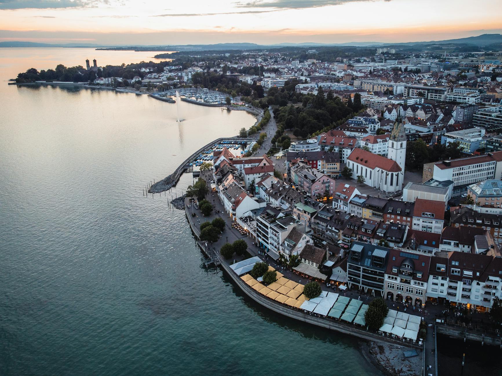 Stunning aerial view of Friedrichshafen, Germany showcasing the waterfront and city at sunset.