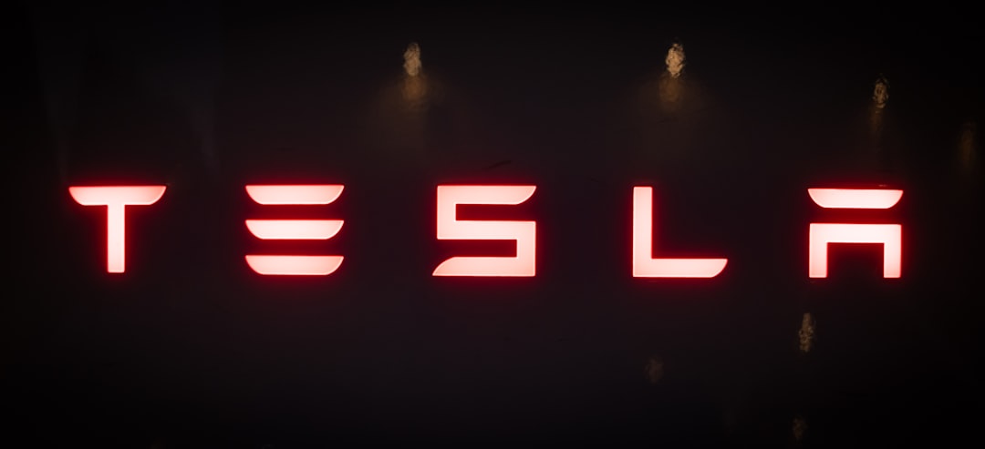 Red tesla logo on a dark background